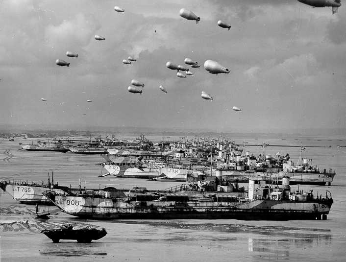 British LCT's line the Normandy shore, each with a barrage balloon designed to discourage enemy air attack.